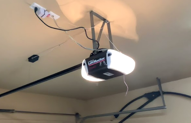 A professional performing a garage door opener installation in a residential home in Grove City, Ohio, highlighting the service's quality and expertise.